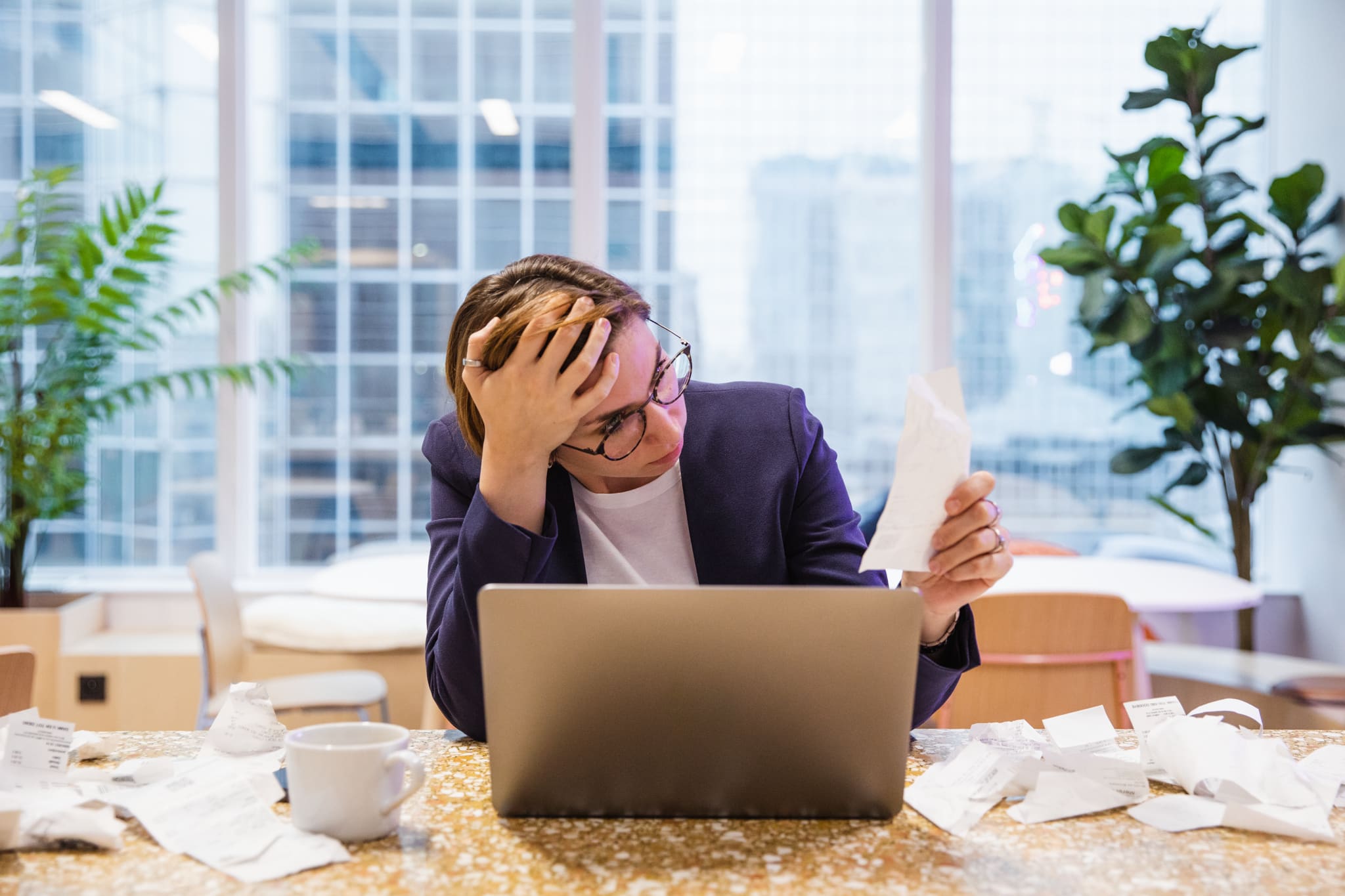 Woman looking frustrated at receipts 