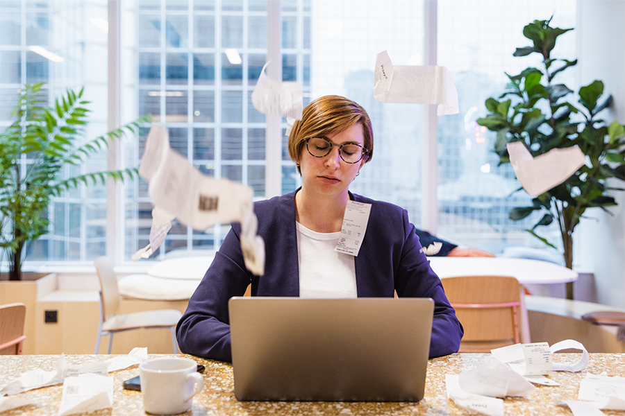 Frustrated woman with receipts flying all over the room. 